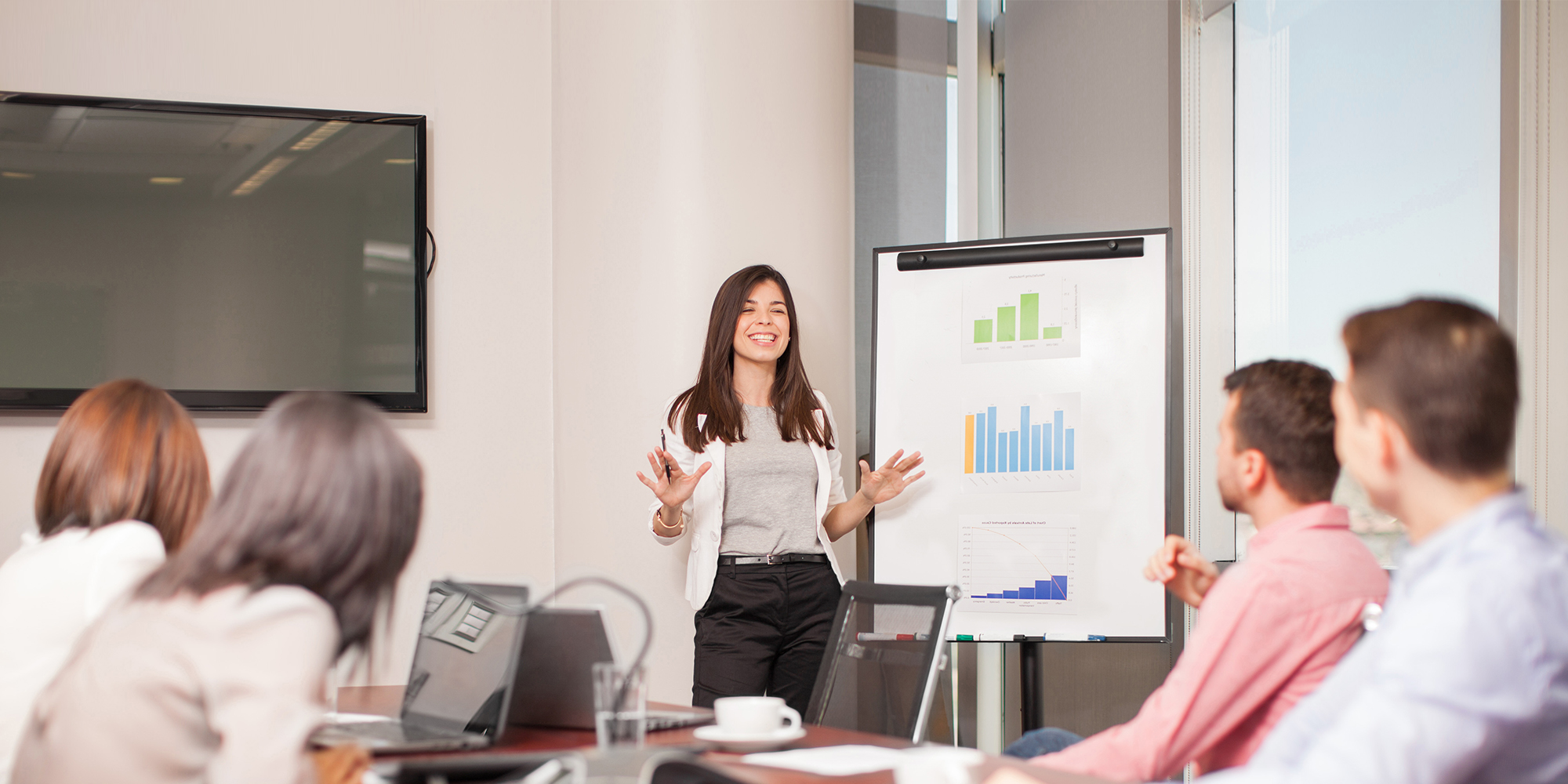 Woman gives pitch presentation to board room 